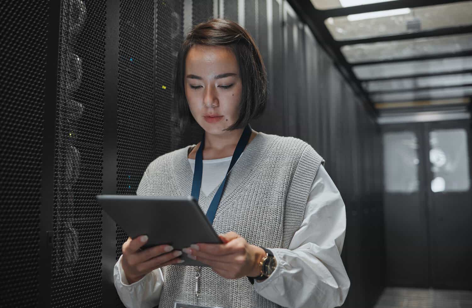 An IT engineer inspects hospital server infrastructure with healthcare data protection controls.