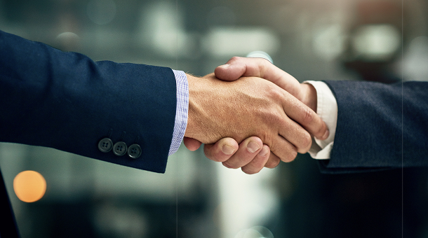 Businessmen shaking hands after coming up with business automation and AI solutions Malaysia.
